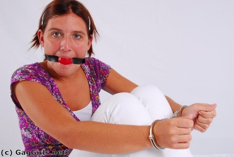 Clothed redhead fits herself with a ball gag while wearing handcuffs | Фото 13