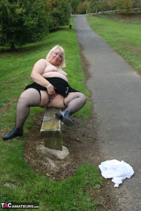 Fat nan Lexie Cummings bares her boobs and big ass on a park bench in nylons | Фото 18