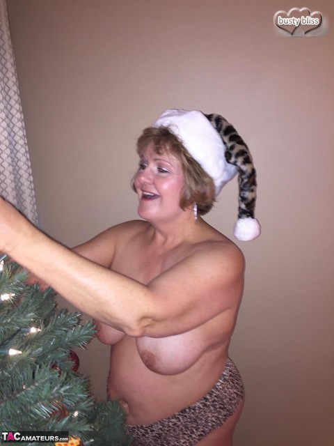 Busty mature woman Busty Bliss pauses for oral sex while dressing an Xmas tree | Фото 1