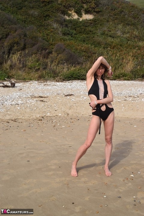 Slender female models a bathing suit while at a deserted beach | Фото 11