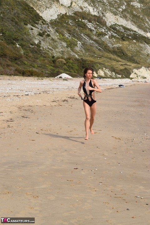 Slender female models a bathing suit while at a deserted beach | Фото 5