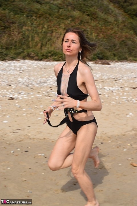 Slender female models a bathing suit while at a deserted beach | Фото 6