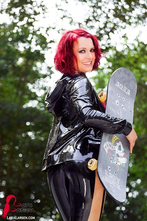 Redheaded model Lara Larsen unzips her latex clothing at a skate park | Фото 6