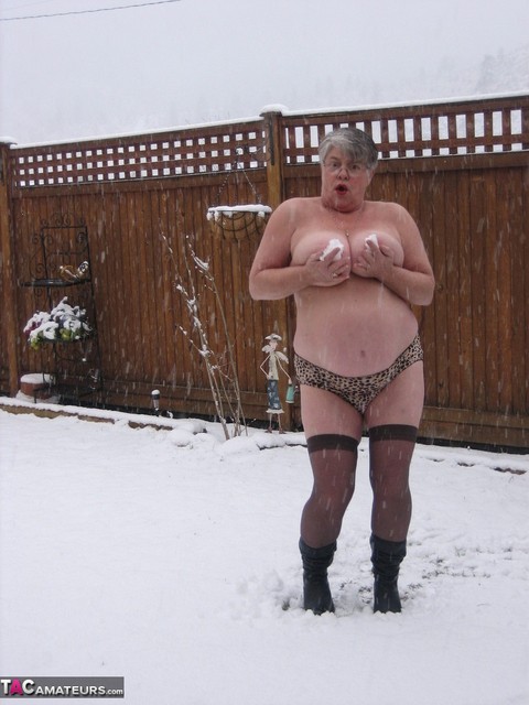 Naughty granny Girdle Goddess strips to her stockings and boots while it snows