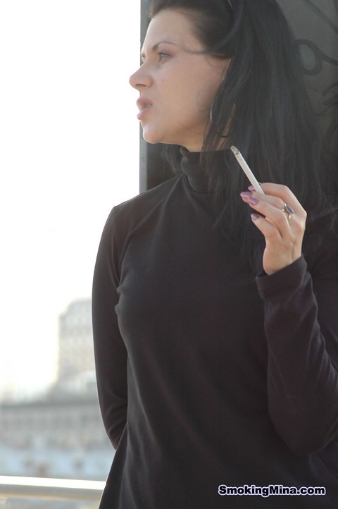 Fully clothed brunette lights up a cigarette with her sunglasses atop her head | Фото 7