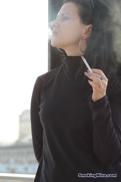 Fully clothed brunette lights up a cigarette with her sunglasses atop her head | Фото 8