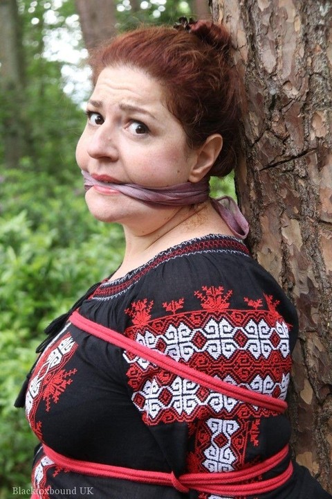 Thick redhead is cleave gagged and tied to a tree in a forest | Фото 14