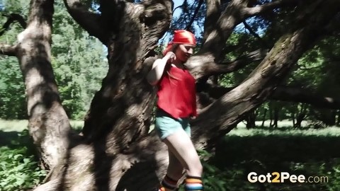 Young blonde Larisa takes a pee behind a tree in multi-coloured knee socks | Фото 14