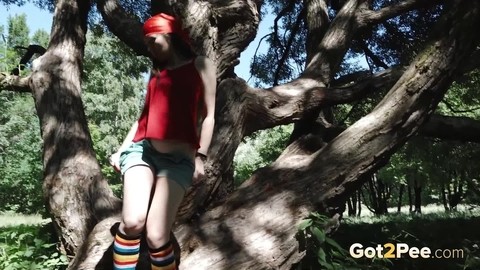 Young blonde Larisa takes a pee behind a tree in multi-coloured knee socks | Фото 3