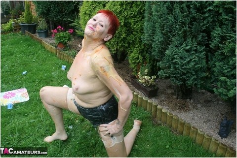 Redhead granny Valgasmic Exposed poses nude in a yard with nylons on | Фото 6