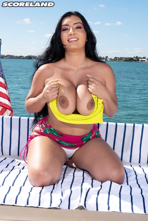 Dark-haired Latina female Selena Adams bares her large boobs on a boat | Фото 12