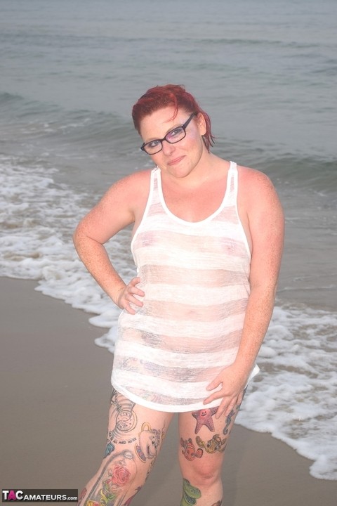 Tattooed redhead wades into the ocean before exposing herself | Фото 1