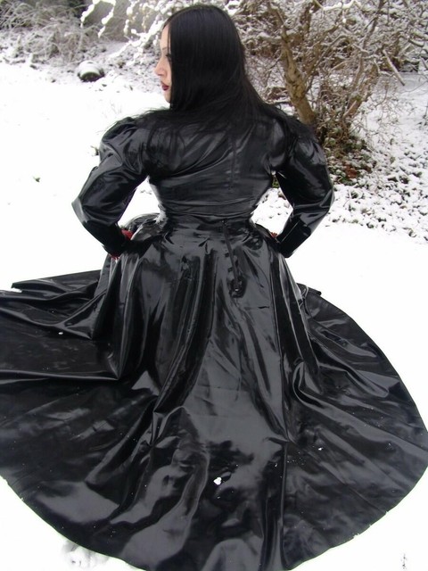 Goth woman Lady Angelina models a black latex dress on snow-covered ground