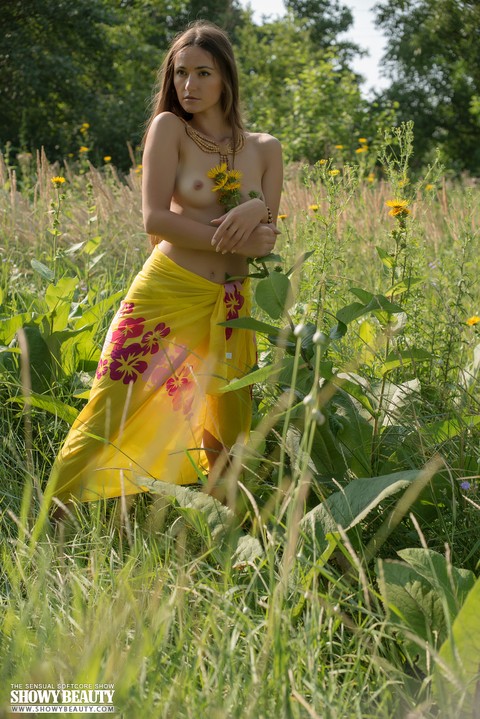 Teen solo girl with small tits takes off her wrap to pose nude among the weeds | Фото 2