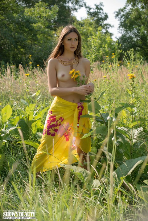 Teen solo girl with small tits takes off her wrap to pose nude among the weeds | Фото 3