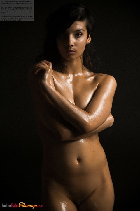 Naked Indian female exposes a single breast while modeling in the dark