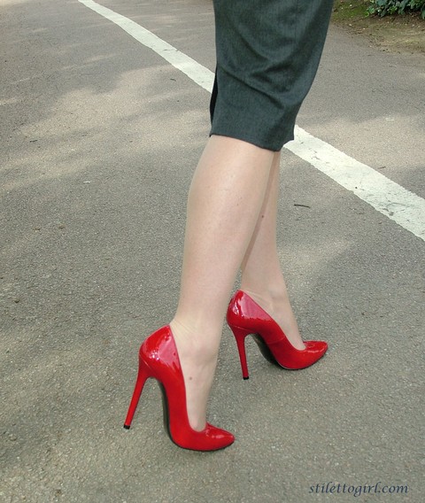 Mature woman crosses her hose covered legs in a long skirt and red pumps | Фото 12