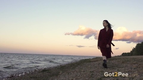 Dark-haired girl Alyona takes a piss while walking on a beach by herself | Фото 1